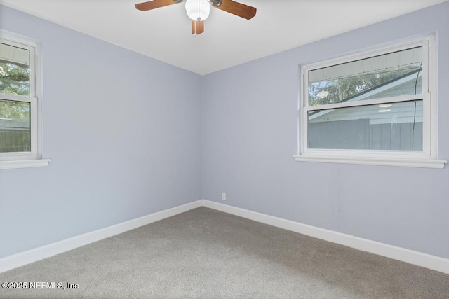 spare room with ceiling fan, carpet floors, and a wealth of natural light