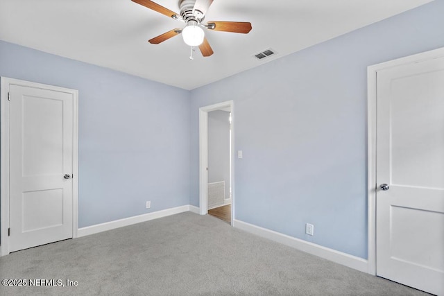 spare room featuring ceiling fan and light carpet