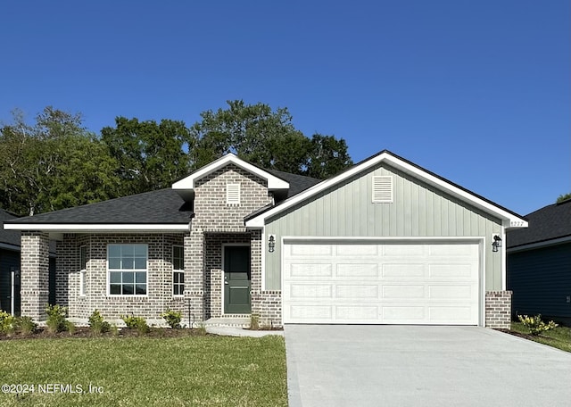 view of front of property with a garage and a front lawn