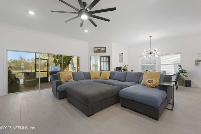 living room with ceiling fan with notable chandelier, light wood-type flooring, and crown molding