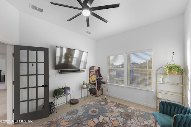 living area featuring light hardwood / wood-style floors and ceiling fan