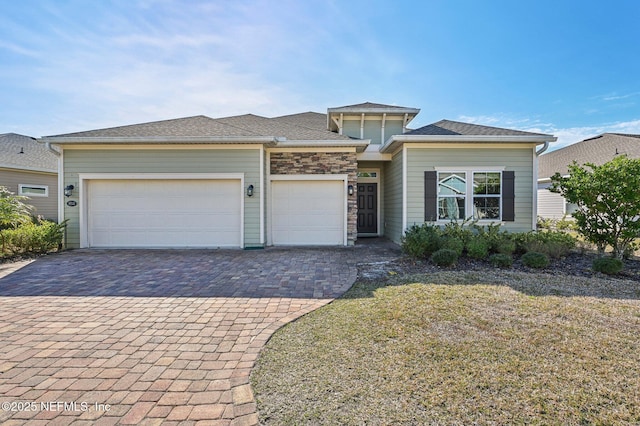 prairie-style home featuring a front yard and a garage