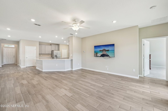 unfurnished living room with ceiling fan and light wood-type flooring