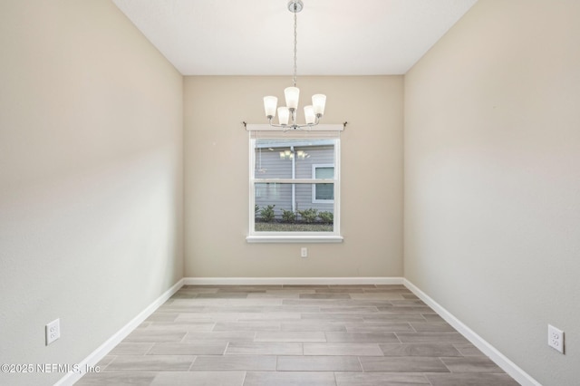 unfurnished room with a chandelier and light hardwood / wood-style flooring