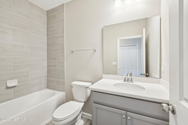 full bathroom with tiled shower / bath, vanity, and toilet