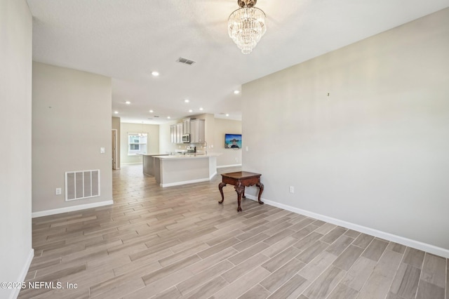 living room featuring light hardwood / wood-style floors and an inviting chandelier