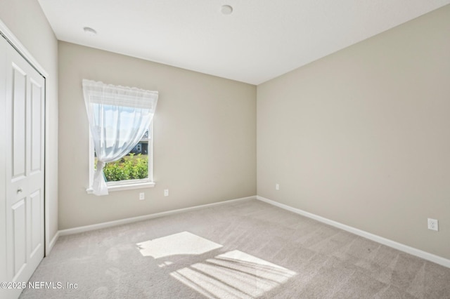 unfurnished bedroom featuring light carpet and a closet