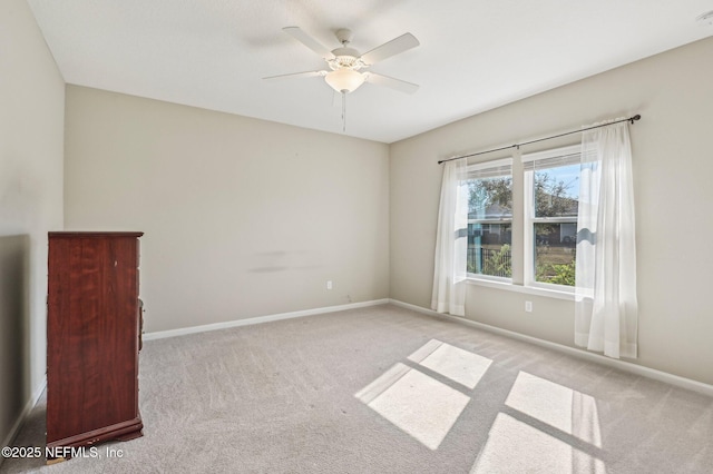 carpeted spare room featuring ceiling fan