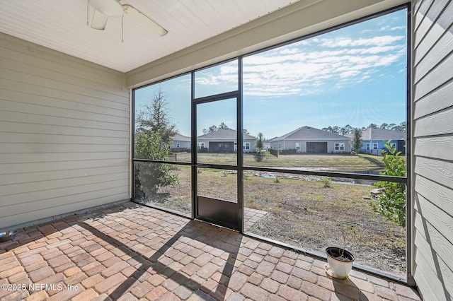 unfurnished sunroom with ceiling fan