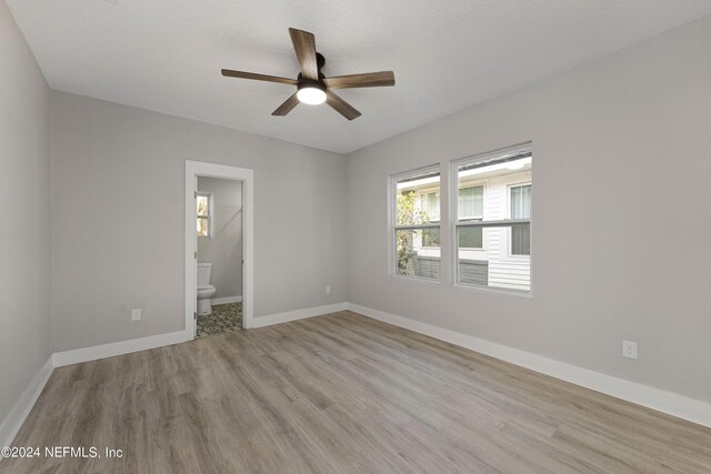 unfurnished bedroom featuring connected bathroom, ceiling fan, and light hardwood / wood-style floors