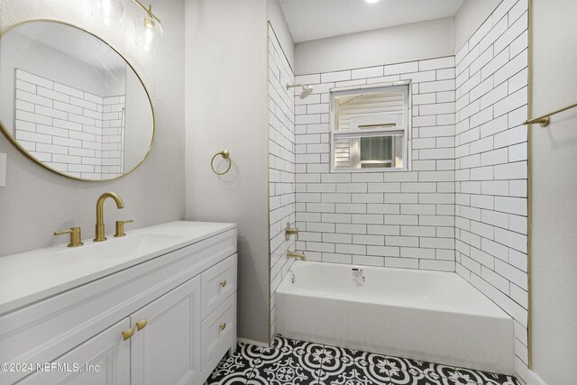 bathroom with tile patterned flooring, vanity, and tiled shower / bath