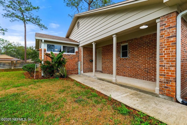 exterior space featuring a yard and brick siding