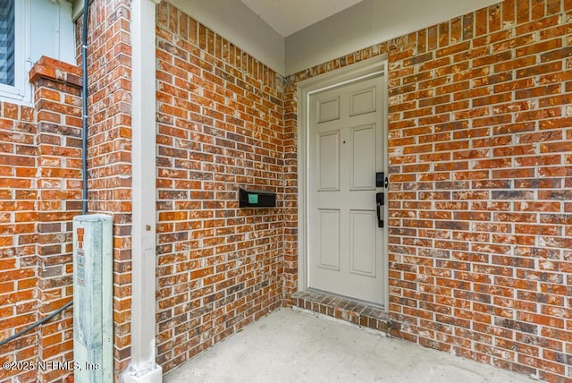 doorway to property with brick siding