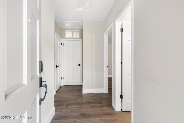 hallway with baseboards and wood finished floors