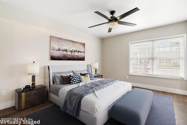 bedroom featuring wood finished floors, a ceiling fan, and baseboards