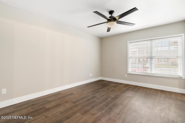 empty room featuring ceiling fan, dark wood-style flooring, and baseboards