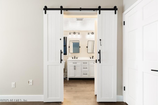 bathroom with double vanity, wood finished floors, and visible vents