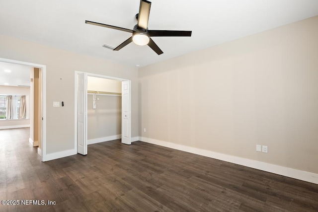 unfurnished bedroom featuring dark wood finished floors, a closet, visible vents, a ceiling fan, and baseboards