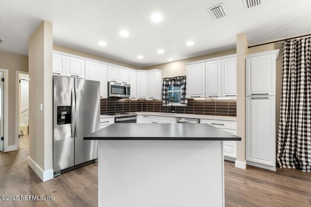 kitchen with white cabinetry, visible vents, appliances with stainless steel finishes, and wood finished floors