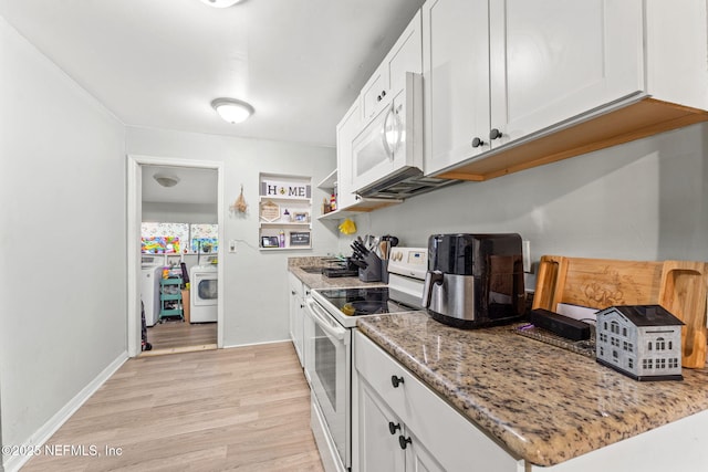 kitchen featuring white appliances, stone counters, white cabinets, light wood-type flooring, and washer / dryer