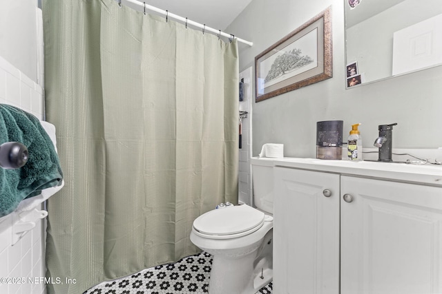 bathroom with curtained shower, vanity, and toilet