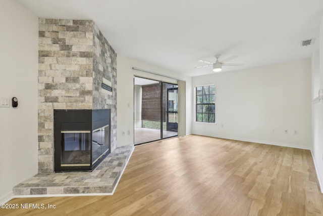 unfurnished living room with ceiling fan, a fireplace, and hardwood / wood-style floors