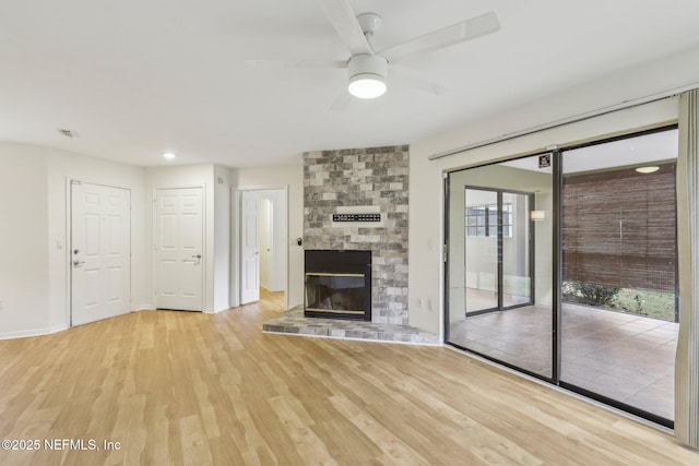 unfurnished living room featuring ceiling fan, a fireplace, and light hardwood / wood-style flooring