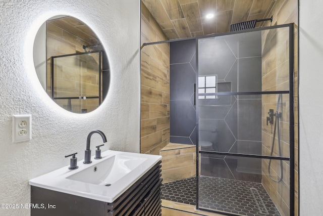 bathroom featuring vanity, toilet, and an enclosed shower