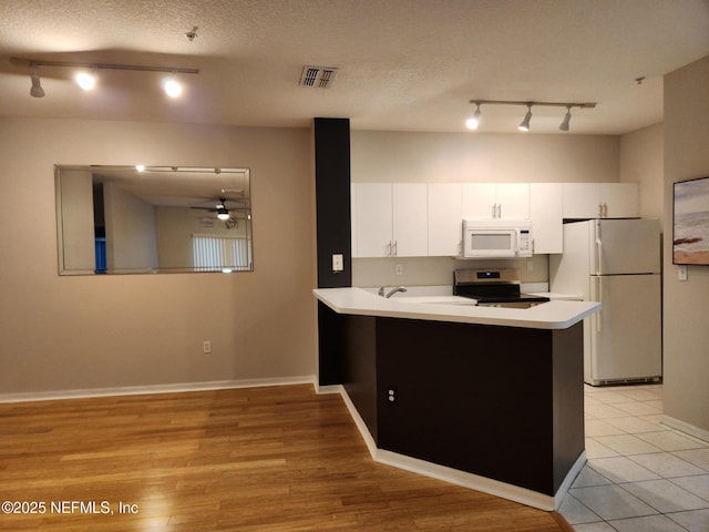 kitchen featuring white appliances, kitchen peninsula, ceiling fan, a textured ceiling, and white cabinetry