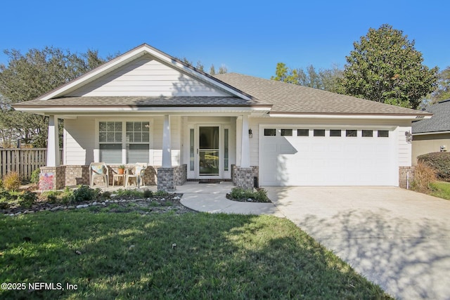 view of front of home featuring a front yard, covered porch, and a garage