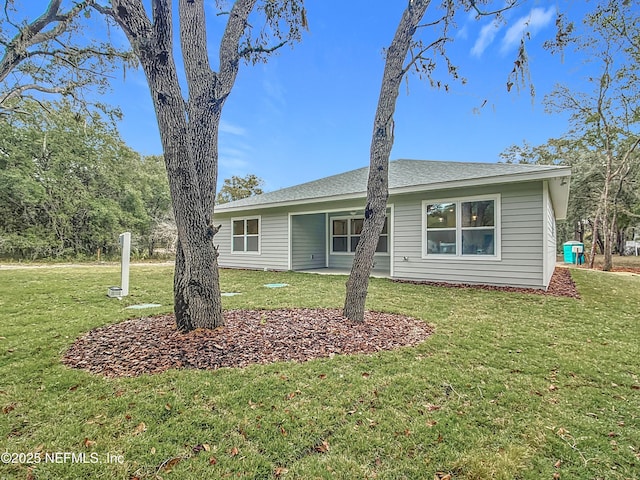 back of property with a yard and a patio area