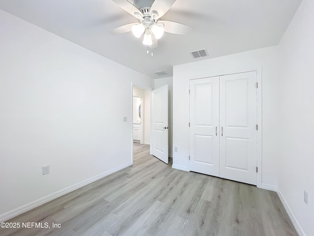 unfurnished bedroom featuring ceiling fan, light hardwood / wood-style floors, and a closet