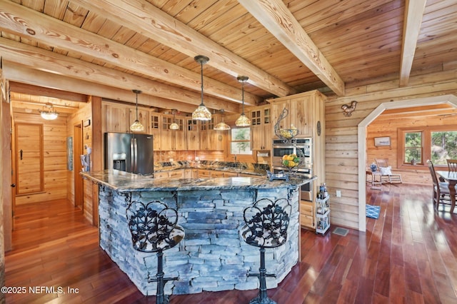 kitchen with pendant lighting, stainless steel appliances, dark hardwood / wood-style flooring, and dark stone counters