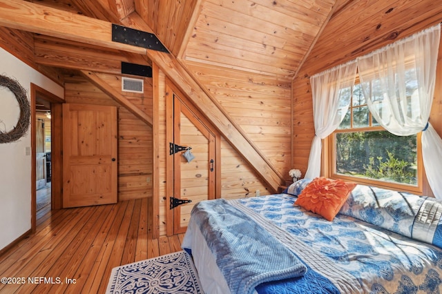 bedroom with hardwood / wood-style flooring, vaulted ceiling, wooden walls, and wood ceiling