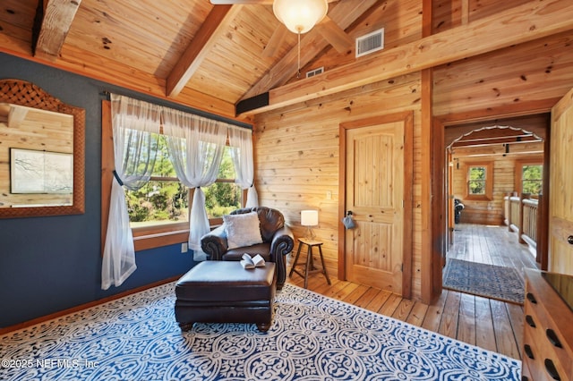 sitting room featuring hardwood / wood-style floors, lofted ceiling with beams, wooden ceiling, and wood walls