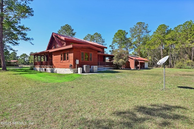 view of side of home with central AC unit and a lawn