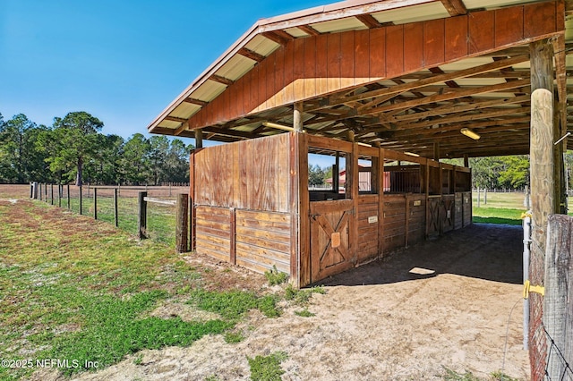 view of horse barn with a rural view