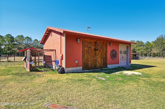 view of outbuilding with a garage and a lawn