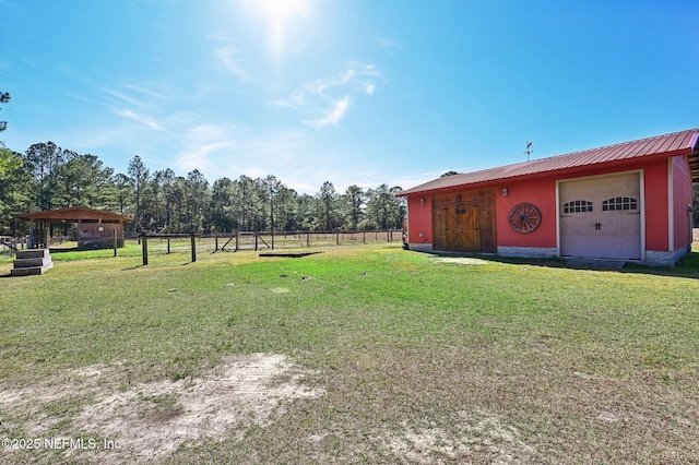 view of yard featuring a garage and an outbuilding