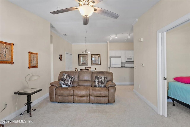 carpeted living room featuring ceiling fan with notable chandelier and crown molding