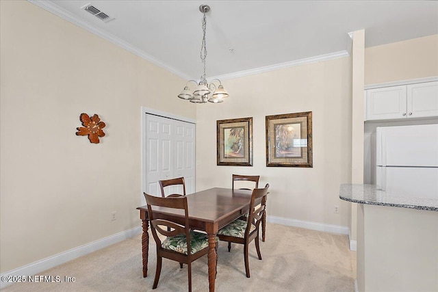 carpeted dining area featuring an inviting chandelier and ornamental molding