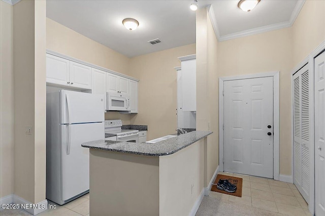 kitchen with white cabinets, light tile patterned flooring, white appliances, and kitchen peninsula