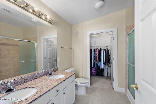 bathroom with tile patterned floors, vanity, toilet, and an enclosed shower