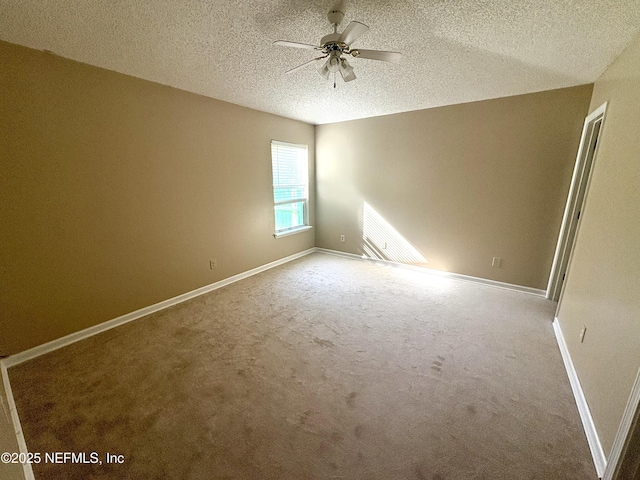 carpeted spare room with ceiling fan and a textured ceiling