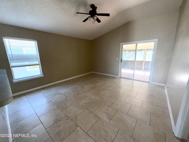 unfurnished room with a textured ceiling, a wealth of natural light, ceiling fan, and lofted ceiling