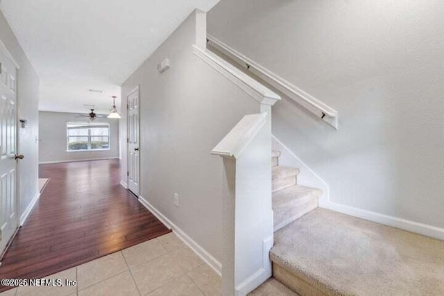 stairway with tile patterned floors and ceiling fan