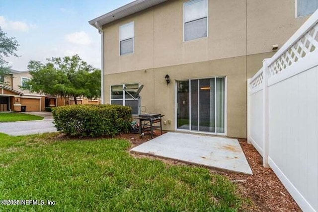 back of property with a patio area and a lawn