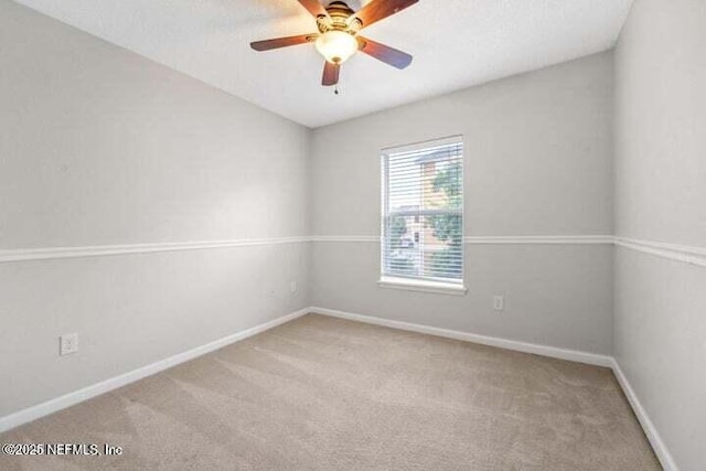 carpeted spare room featuring ceiling fan