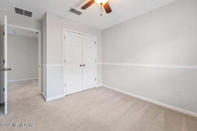 unfurnished bedroom featuring a closet, ceiling fan, and light colored carpet