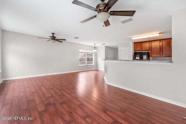 unfurnished living room with ceiling fan, dark hardwood / wood-style flooring, and a textured ceiling